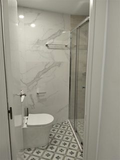 Baño reformado en Barcelona con alicatado tipo mármol