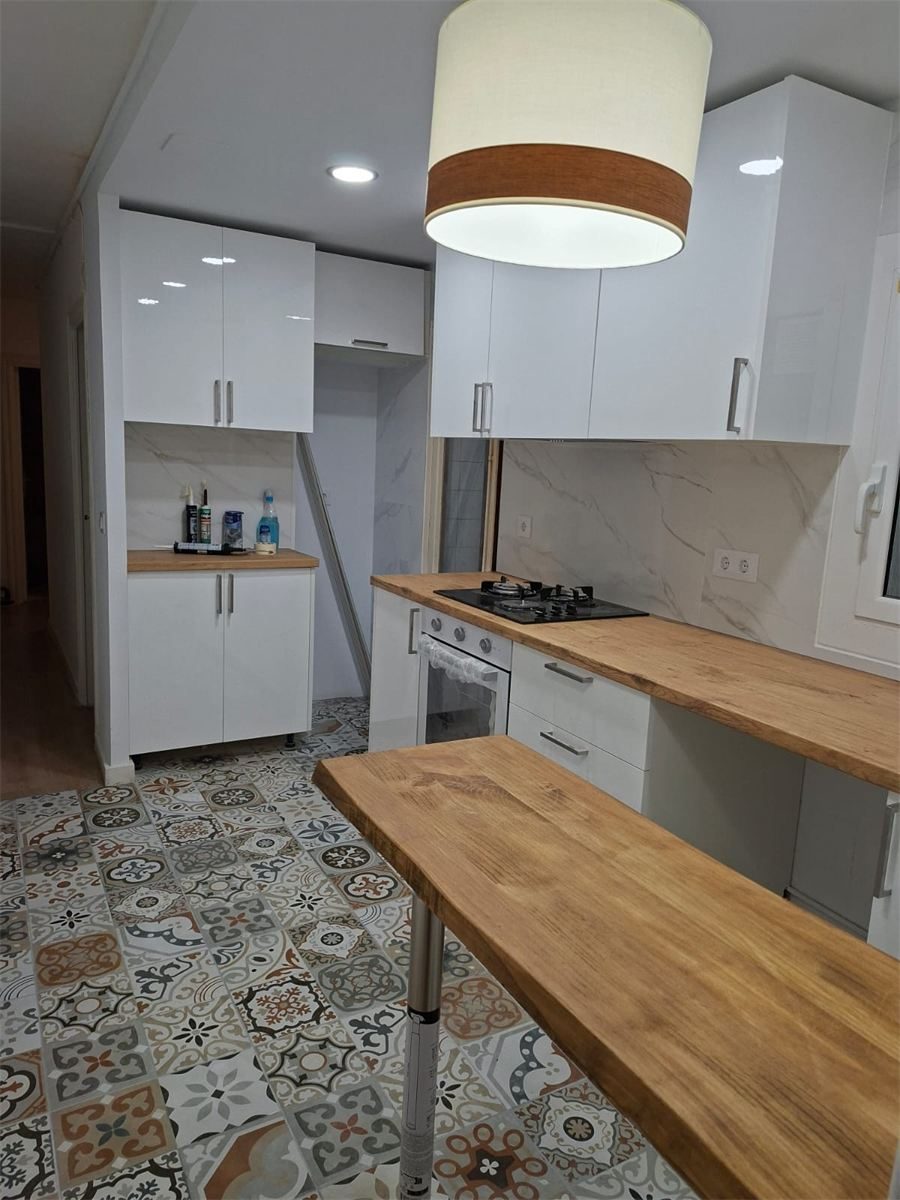 Cocina reformada en Barcelona, con muebles nuevos y suelo de estilo hidráulico