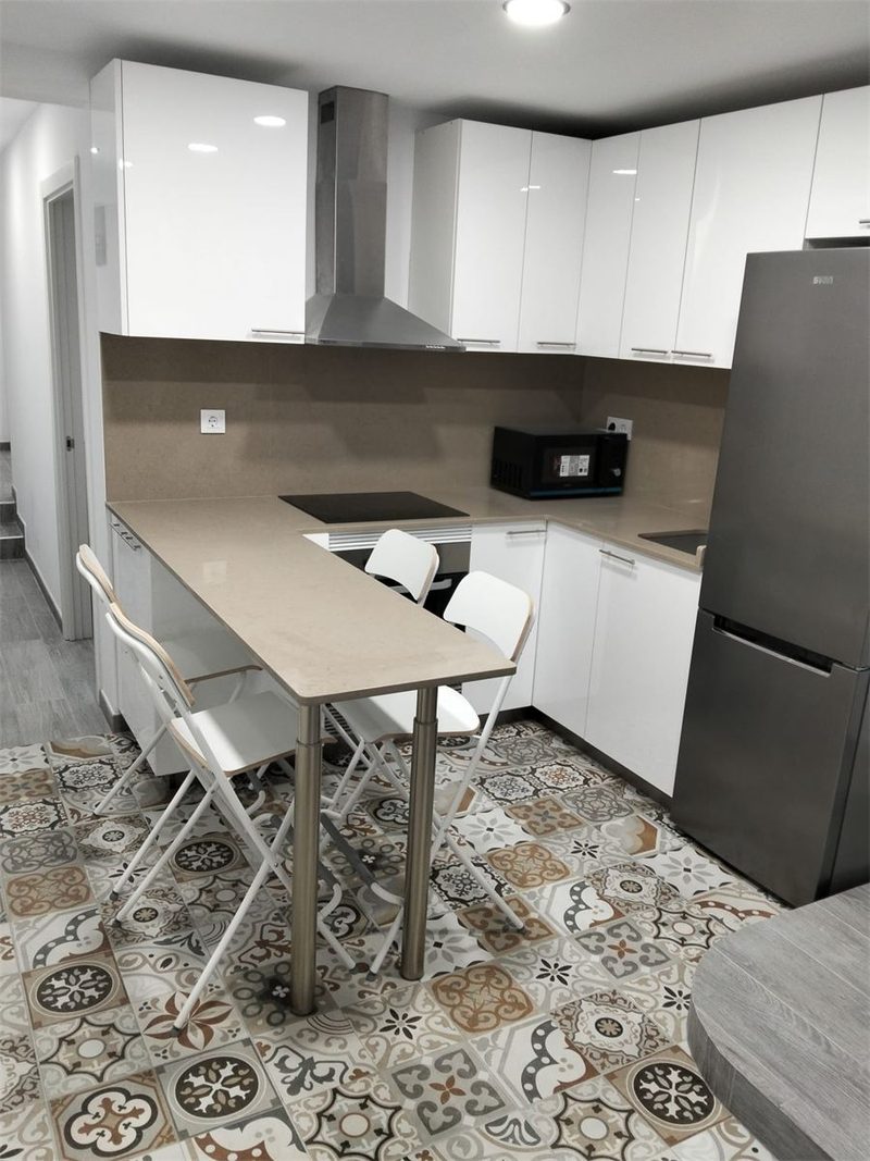 Cocina reformada en Barcelona con muebles blancos