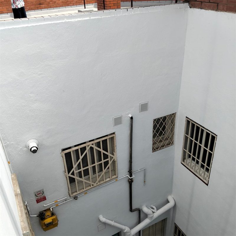 Patio interior de comunidad pintado de blanco en Barcelona