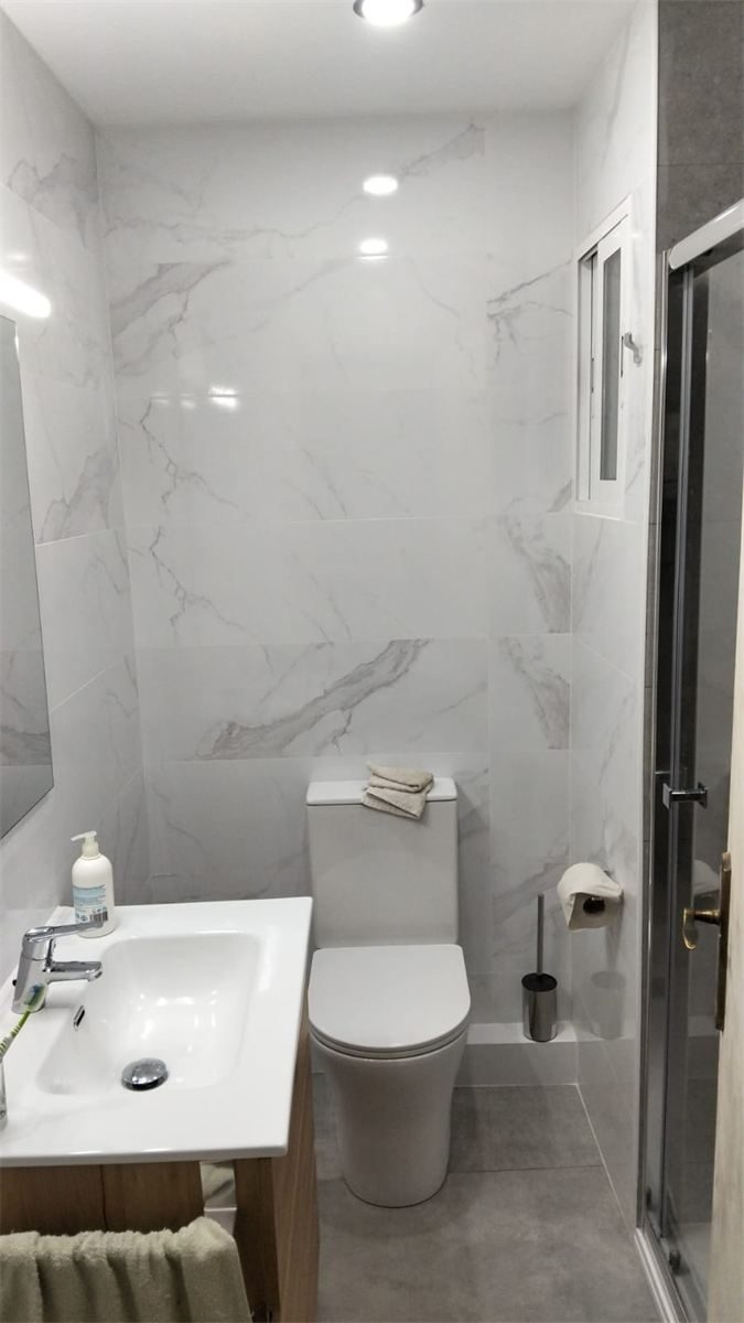 Baño reformado en Barcelona, con alicatado tipo mármol